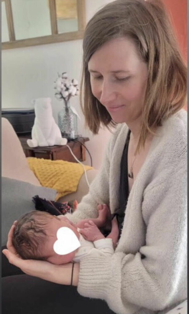Coline tenant un enfant dans ses bras et souriant