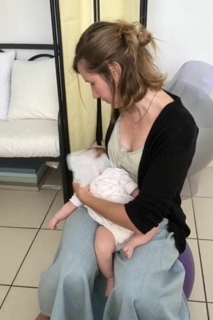 Coline tenant un enfant dans ses bras
